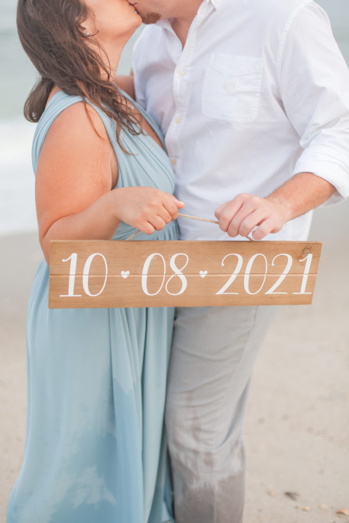 save the date sign engagement photo on the beach